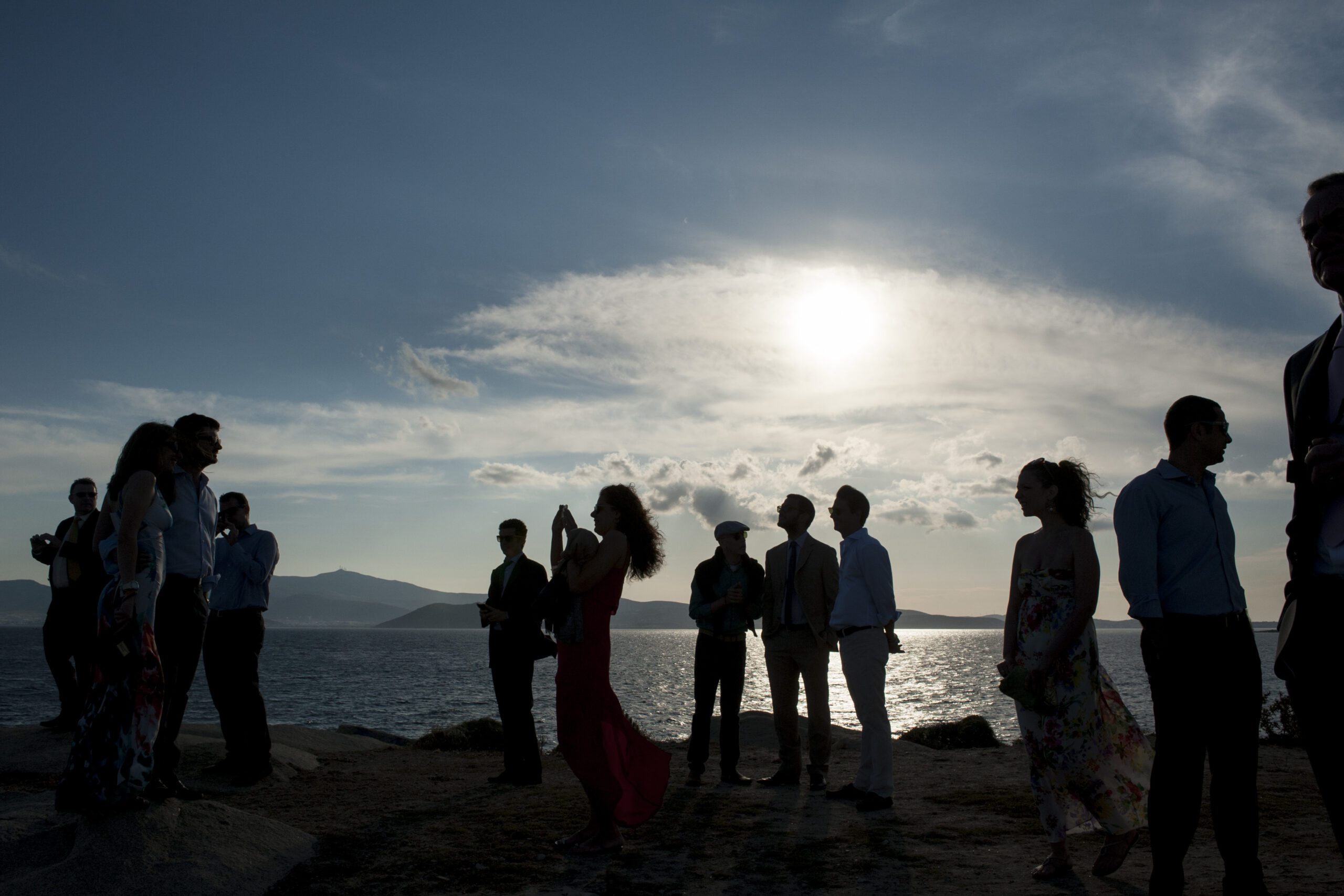 People on sunset on the rocks by the sea